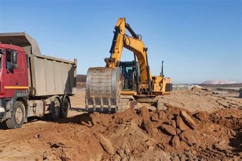 Premium Photo A Powerful Crawler Excavator Loads The Earth Into A