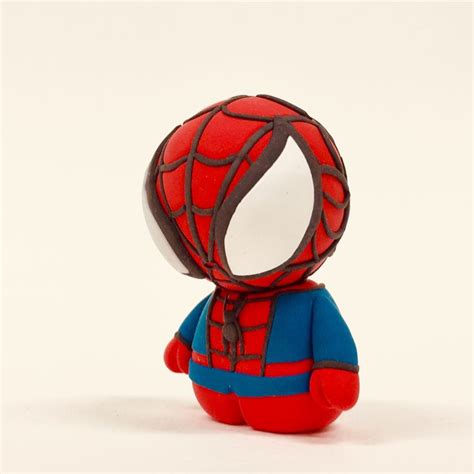 A Spider Man Toy Sitting On Top Of A White Surface