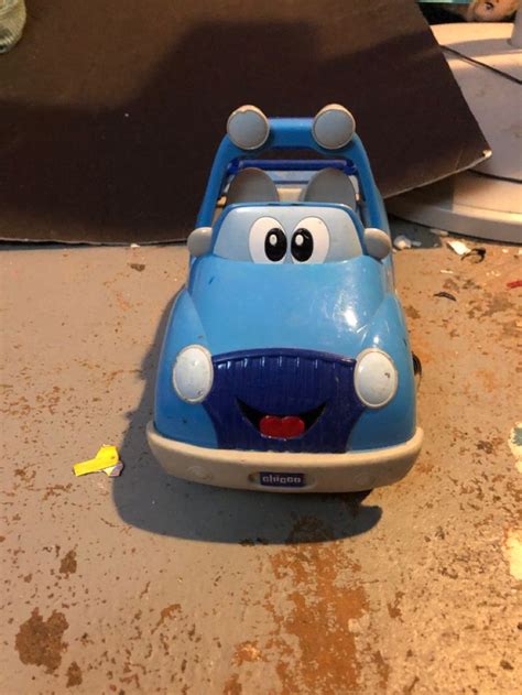 A Blue Toy Car Sitting On Top Of A Dirty Floor