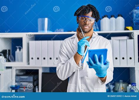 African American Man Scientist Using Touchpad At Laboratory Stock Photo