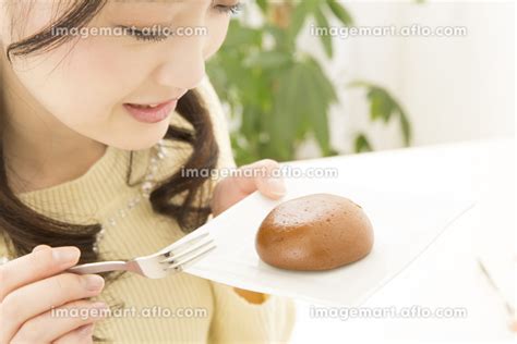 お菓子を食べる女性の写真素材 141548116 イメージマート