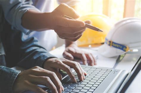 Premium Photo Cropped Image Of Engineers Using Laptop In Office