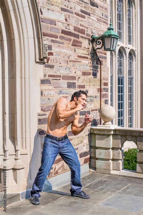 Dressing In Jeans And Leather Sneakers And Half Naked A Handsome Muscular Guy Is Waving Arms