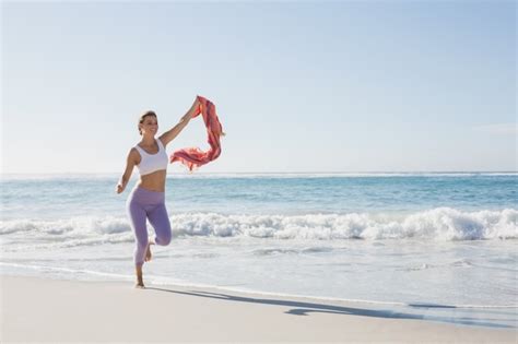 Premium Photo Sporty Blonde Jogging On The Beach With A Scarf