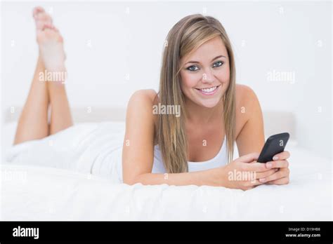 Blonde Woman Lying On The Bed With Her Phone Stock Photo Alamy