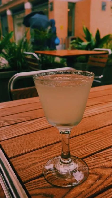 A Glass Filled With Liquid Sitting On Top Of A Wooden Table