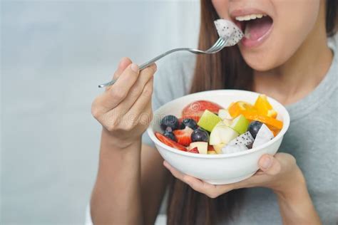 Young Women Enjoy Eating Fruits Salad From A Bowl To Be Healthy Stock