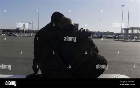 Jeune gay couple masculin assis sur un banc à l arrêt de bus parlant et embrassant HDR Deux