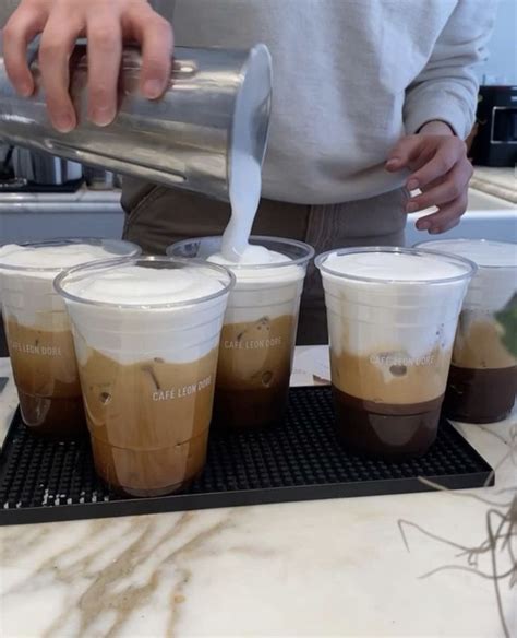 A Person Pours Coffee Into Four Cups