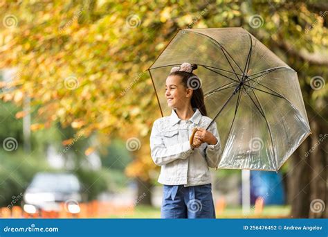 Kid Playing Out in the Rain. Children with Umbrella Play Outdoors in ...