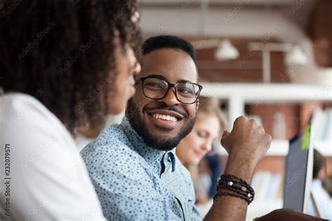 Close Up Of Smiling African American Employee Look At Female Colleague