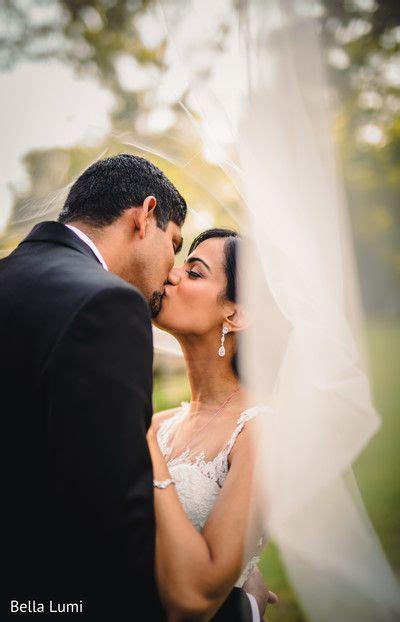 A Bride And Groom Kissing Under The Veil