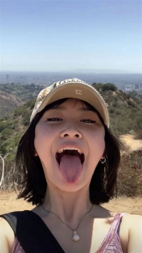 A Woman With Her Mouth Open In Front Of The Camera Taking A Selfie On Top Of A Hill