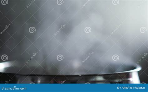 Steam Rising From Pot With Boiling Water On Kitchen Slow Motion Stock