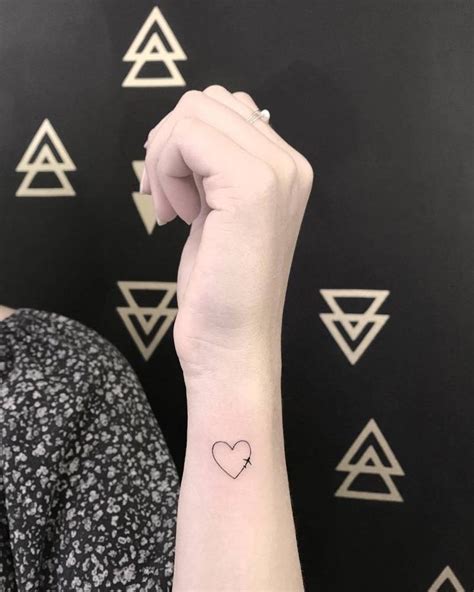 A Woman S Arm With A Small Heart Tattoo On The Left Side Of Her Wrist