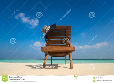 Chaises De Plage Avec Le Chapeau Sur La Plage Sablonneuse Blanche Image