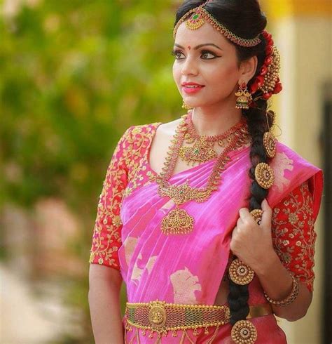 A Woman Wearing A Pink Sari And Gold Jewelry