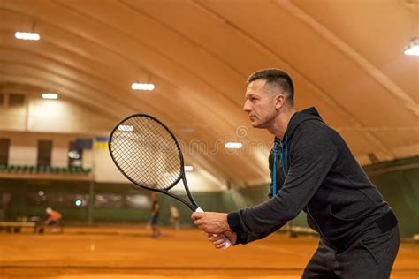 Full Length Portrait Of Agile Male Athlete Playing Tennis On Indoor