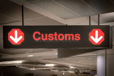 Customs Sign In Airport And Direction Arrow Red And Lighted Stock