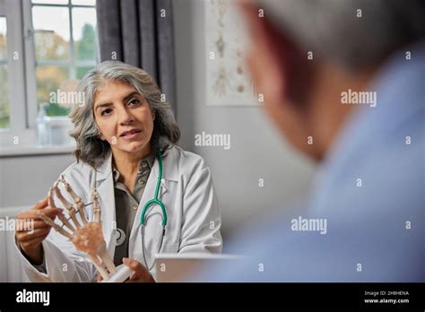 Rencontre de médecin de femme mature avec un patient de sexe masculin discutant de la douleur