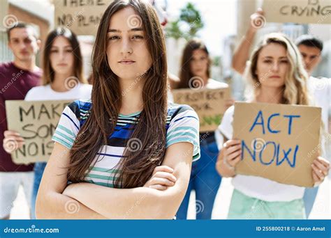 Young Activist Woman With Arms Crossed Gesture Standing With A Group Of