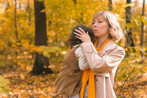 Mère apaise sa fille blonde en pleurs maman tient bébé triste dans ses bras dans la nature d
