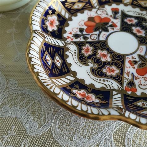 An Ornately Decorated Plate Sitting On Top Of A Lace Covered Tablecloth