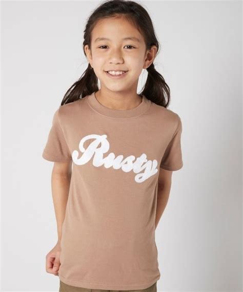 Rusty（ラスティ）の「【rusty ラスティ】キッズ ロゴ 半袖tシャツ バックプリント ニコちゃん 刺繍（tシャツ カットソー）」 Wear