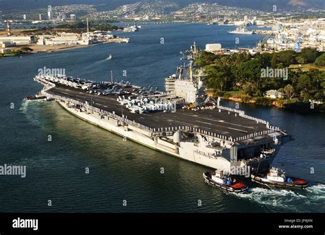 The Aircraft Carrier Uss Ronald Reagan Cvn 76 Is Aided By Harbor Tugs