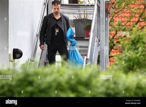 An Investigator Carries A Box With Seized Items From An Apartment Of A