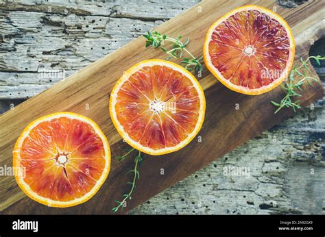 Sliced Blood Oranges With Thyme On Wooden Board Citrus Background Cut