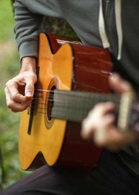 Premium Photo Young Man Plays Acoustic Guitar On Nature In Forest