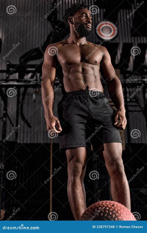 Portrait Of Confident Muscular Male With Naked Torso Posing Standing After Workout In Gym Stock