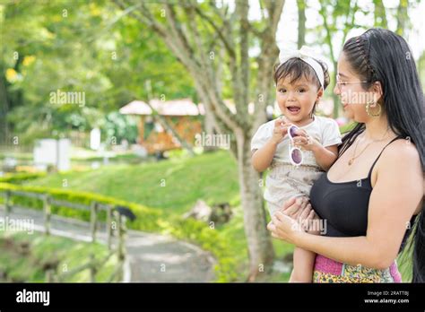 Latina Mother Holding Her Smiling Baby Daughter And Proudly Admiring Her Innocence Stock Photo