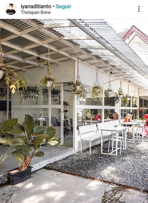 People Are Sitting At Tables Under The Awning In Front Of A Building