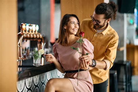 Romantic Man Surprising His Girlfriend With Red Rose During A Date In A