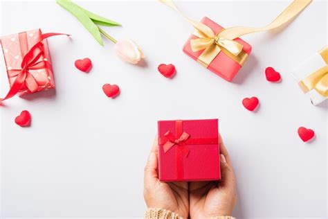 Día de san valentín y cumpleaños manos de mujer sosteniendo regalo o