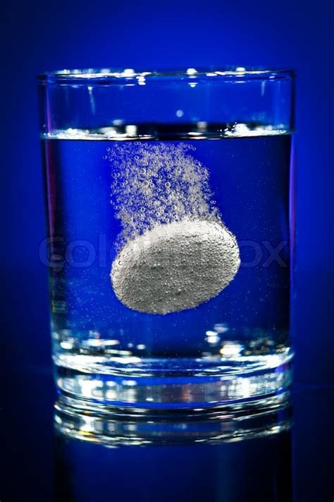 Effervescent Tablet In Water With Bubbles On A Blue Background Stock