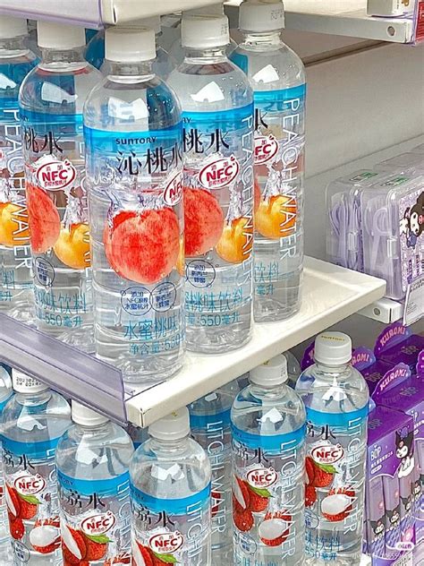 Several Bottles Of Water And Oranges Are On Display In A Grocery Store