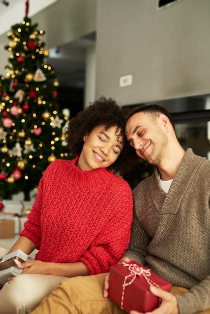 Casal afetuoso trocando presentes de natal Foto Grátis