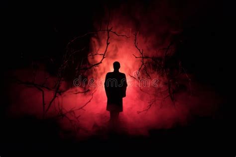 Silhouette Of Man In Dark Haunted Scary Forest On Halloween Night Stock