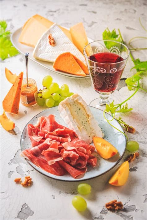 Ham and Cheese Platter with Grapes, Nuts and Red Wine Stock Photo ...