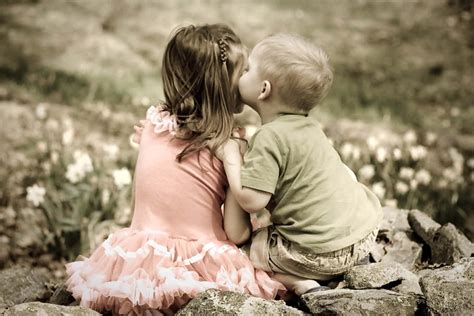 Download Cute Baby Couple Kissing In The Garden Wallpaper