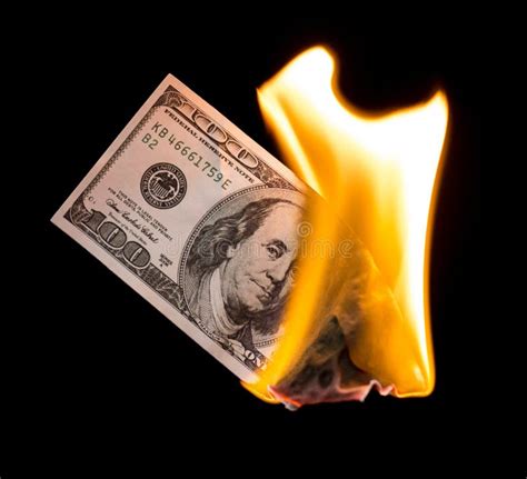 A Hundred Dollars Burn In A Fire On A Black Background Stock Photo