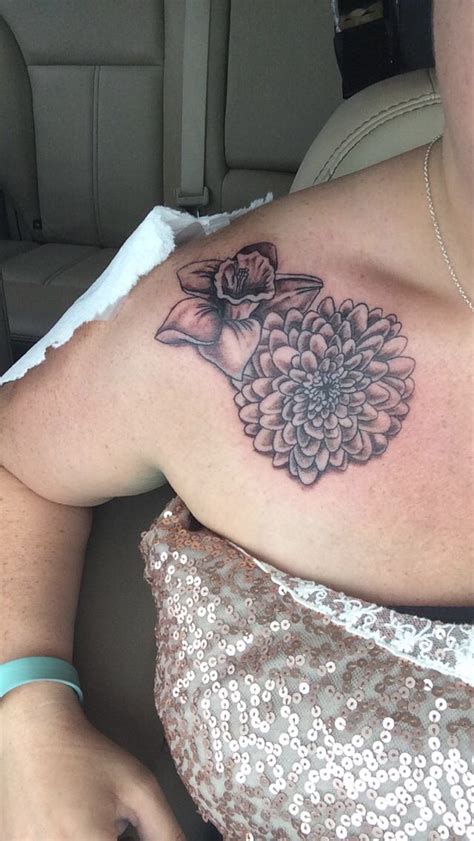 A Woman With A Flower Tattoo On Her Shoulder