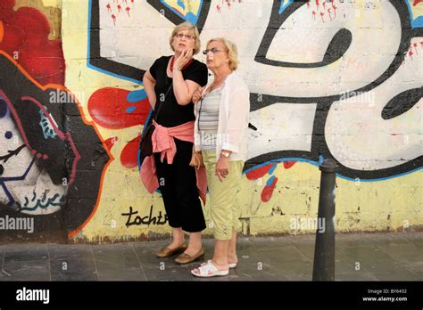 Two Women Admiring Graffiti In Valencia Backstreet Spain Stock Photo