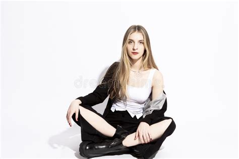 Sourire Sensuel Charmante Fille Blonde En Costume Noir Assise Sur Fond Blanc Pur Photo Stock