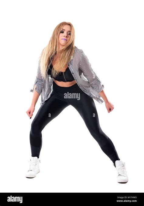 Jolie femme blonde danse aux longs cheveux et vêtements à la recherche vers le bas La pleine