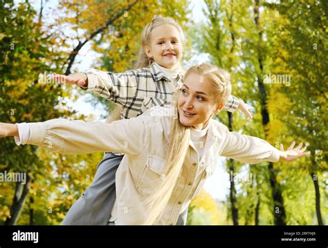 Mother And Daughter Spend Time Together In The Autumn Park The Mother