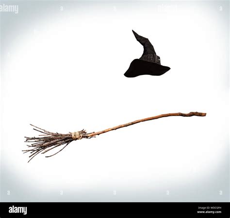 classic pointed witch hat and flying broom flying on a white background ...